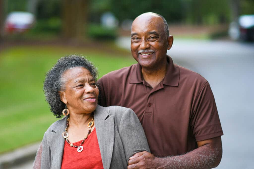 An older couple walking down the street.