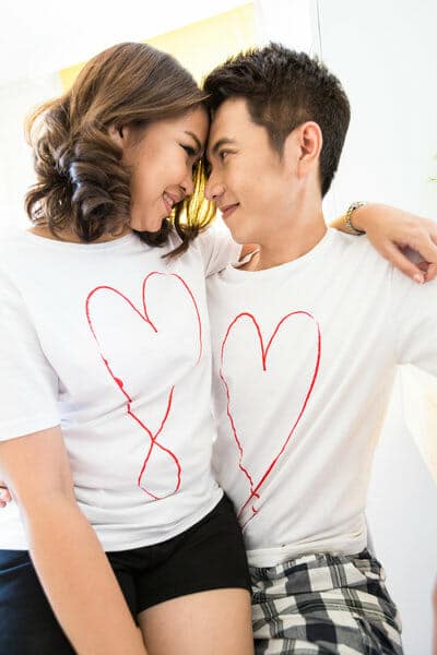 A man and woman wearing t - shirts with hearts on them.