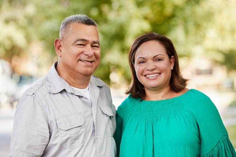 A man and woman standing in a park.