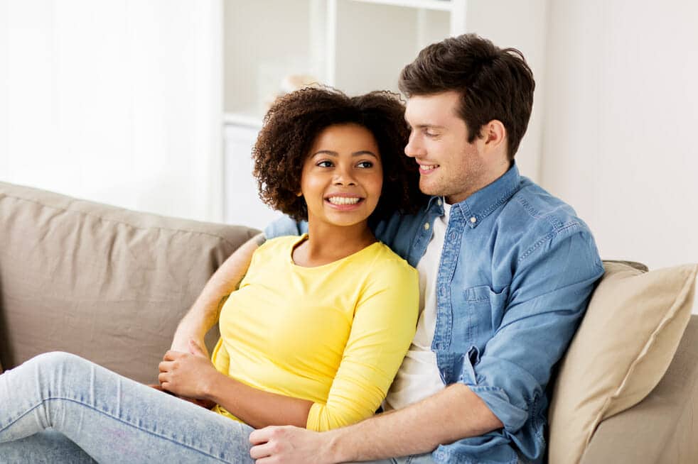 A man and woman sitting on a couch together.