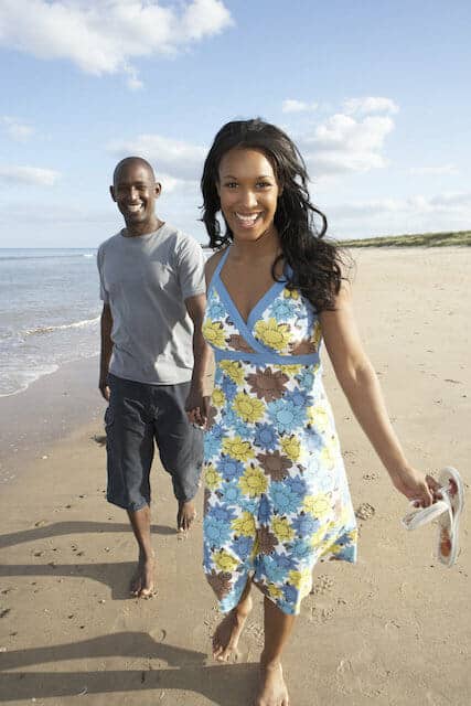 A man and woman walking on the beach.