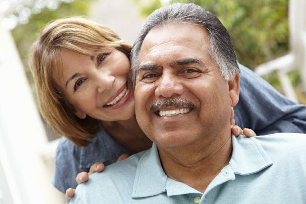 An older man and woman smiling at each other.