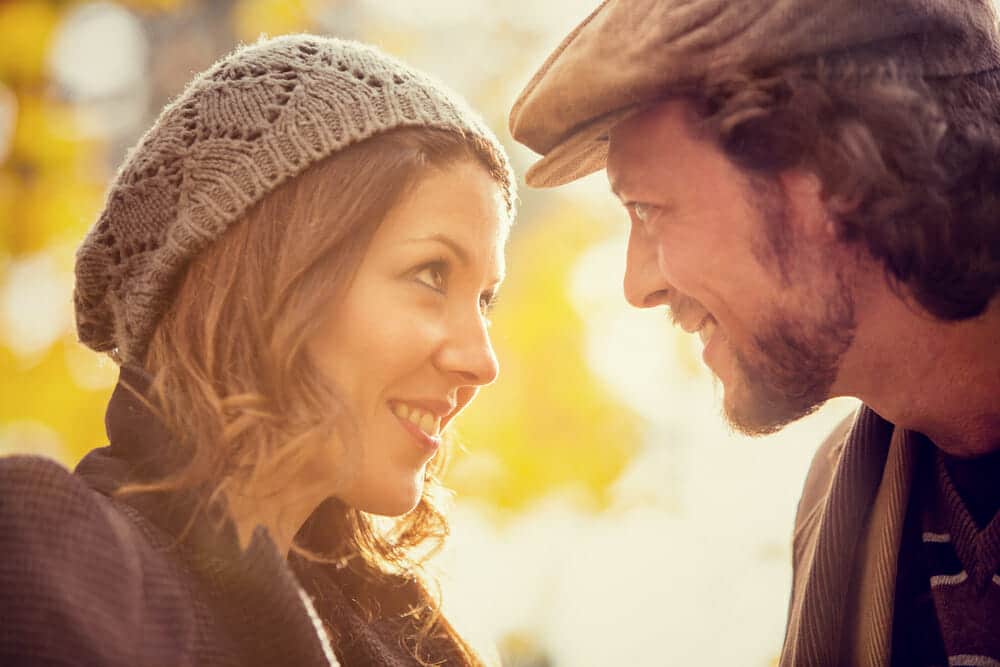 A man and woman looking at each other in a park.