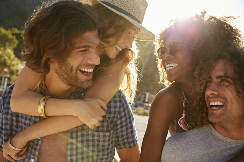 A group of friends laughing together on a beach.