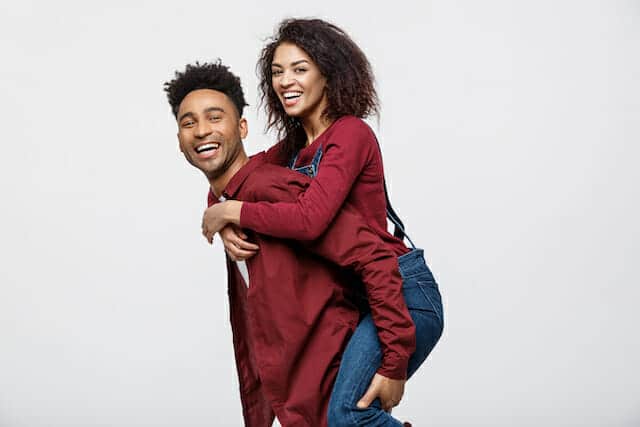 A man is carrying a woman on his back.