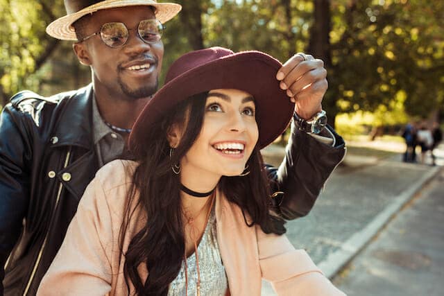 A man and woman are riding a bike in a park.