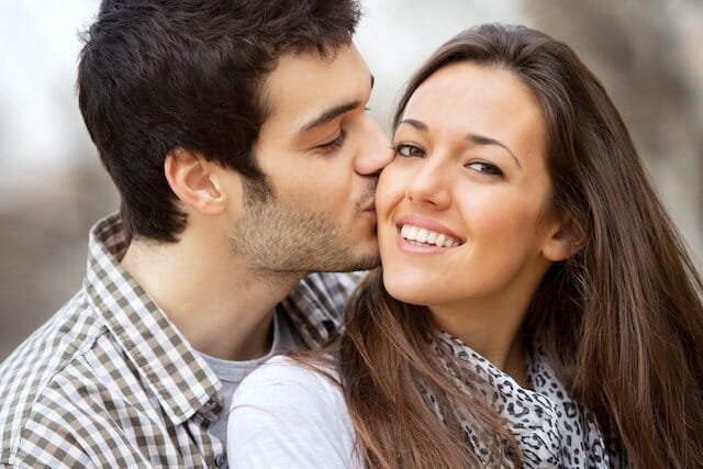 A young man and woman kissing each other.