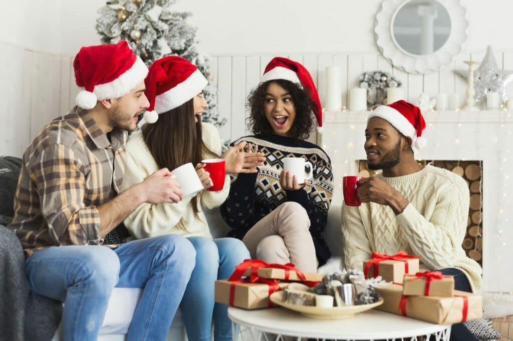 A group of people in santa hats sitting on a couch.