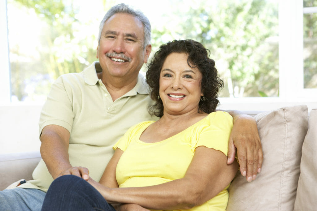 An older couple sitting on a couch.