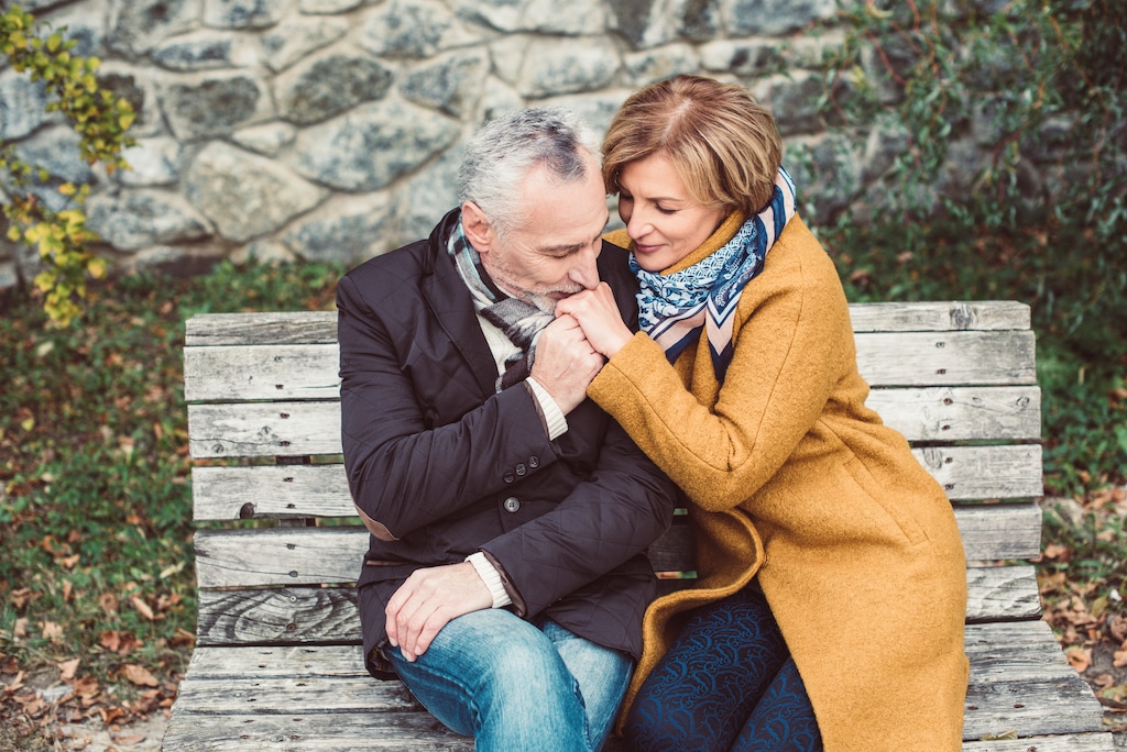 An older couple sitting on a bench.