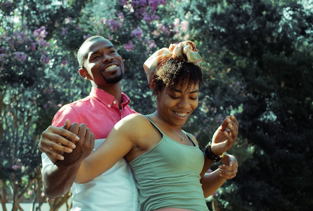 A man and woman are dancing in the park.