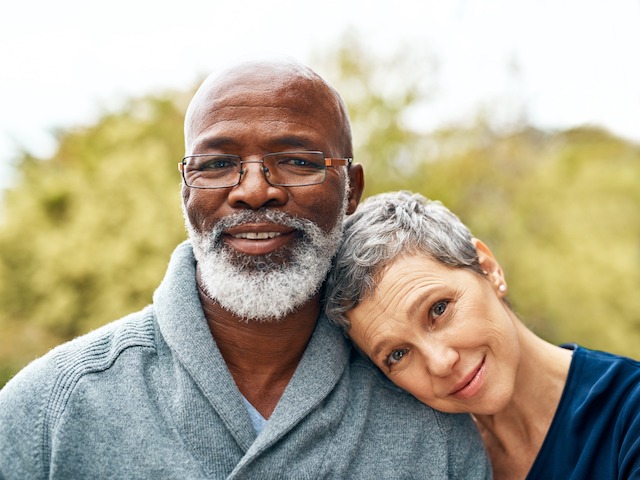 An older black man and woman posing for a photo.